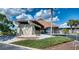 Exterior of a clubhouse featuring stone accents, a well-maintained landscape, and a welcoming entrance at 13575 Martha Ave, Port Charlotte, FL 33981