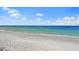 Calm ocean view under a blue sky with fluffy clouds, showcasing the serene and peaceful coastal scenery at 17128 Blowfish Dr, Nokomis, FL 34275