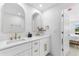Bathroom featuring double sink vanity, modern fixtures, mirrors and white cabinets at 23 Ocean Dr, Punta Gorda, FL 33950