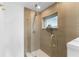 Modern bathroom featuring a glass shower with gold fixtures and textured tile walls at 23 Ocean Dr, Punta Gorda, FL 33950