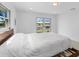 Bright bedroom featuring white walls, neutral bedding, and backyard water views at 23 Ocean Dr, Punta Gorda, FL 33950