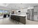 Modern white kitchen with stainless steel appliances, large island and countertop seating at 23 Ocean Dr, Punta Gorda, FL 33950