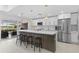 Modern white kitchen with stainless steel appliances, large island and countertop seating at 23 Ocean Dr, Punta Gorda, FL 33950