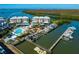 Stunning aerial view showcasing waterfront condominiums, a community pool, and private boat docks on the serene water at 2424 Placida Rd # C104, Englewood, FL 34224