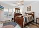 Bedroom with wood-look floors and a large window with plantation shutters, and stylish decor at 2424 Placida Rd # C104, Englewood, FL 34224