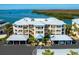 Exterior view of a condo building with blue awnings, white balconies, and covered carports at 2424 Placida Rd # C104, Englewood, FL 34224