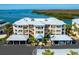 Exterior view of a condo building with blue awnings, white balconies, and covered carports at 2424 Placida Rd # C104, Englewood, FL 34224
