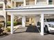 A covered carport features white support beams for parking at this condo building at 2424 Placida Rd # C104, Englewood, FL 34224