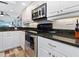 Kitchen featuring stainless steel oven, black cooktop, and white cabinets at 2424 Placida Rd # C104, Englewood, FL 34224
