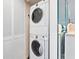 Stacked, white washer and dryer set with folding doors, ready for laundry day at 2424 Placida Rd # C104, Englewood, FL 34224
