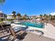 Community pool featuring lounge chairs, a white fence, and palm trees near condo buildings at 2424 Placida Rd # C104, Englewood, FL 34224