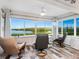 The sun room provides spectacular views from oversized windows, comfortable chairs, and wood-look tile at 2424 Placida Rd # C104, Englewood, FL 34224