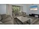 Bright living room with stylish seating, wood-look floors, and backyard views at 2625 Pine Lake Ter # B, Sarasota, FL 34237