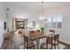 Bright dining area featuring a modern chandelier, a wooden table for six, and an open view to the living room at 2720 60Th Avenue W Dr, Bradenton, FL 34207