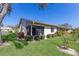 Back exterior with a sunroom, well-maintained lawn, and landscaping for beautiful curb appeal at 2720 60Th Avenue W Dr # D, Bradenton, FL 34207