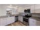 Modern kitchen with stainless steel appliances, granite countertops, and white cabinetry at 2720 60Th Avenue W Dr # D, Bradenton, FL 34207