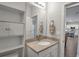 Bright bathroom featuring a large mirror, modern vanity, and open shelving at 2877 Sultan Ct, North Port, FL 34286