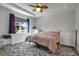 Bright bedroom with a ceiling fan, large window, and neutral-colored bedding at 2877 Sultan Ct, North Port, FL 34286