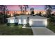 Home exterior at sunset with a manicured lawn, a two-car garage, and lush landscaping at 2877 Sultan Ct, North Port, FL 34286