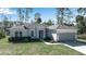 Beautiful home with manicured lawn, a two-car garage, and lush landscaping at 2877 Sultan Ct, North Port, FL 34286