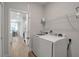 Modern laundry room equipped with a white washer and dryer set and storage at 2877 Sultan Ct, North Port, FL 34286