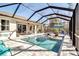Screened pool area featuring in-pool loungers, seating, and brick paver decking at 2877 Sultan Ct, North Port, FL 34286