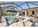 Screened pool area featuring in-pool loungers, seating, and brick paver decking at 2877 Sultan Ct, North Port, FL 34286