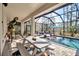 Inviting screened-in pool area with comfortable seating and an outdoor dining space at 2877 Sultan Ct, North Port, FL 34286