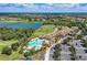 Aerial view of the community clubhouse, pool, and surrounding landscape with golf course and lake at 324 Whispering Palms Ln, Bradenton, FL 34212