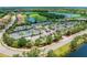 An aerial view shows the tennis courts, parking, and golf course in a beautiful community at 324 Whispering Palms Ln, Bradenton, FL 34212