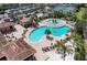 Aerial view of a community pool area with red umbrellas and palm trees at 324 Whispering Palms Ln, Bradenton, FL 34212