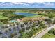 Aerial view showcasing the community clubhouse, pool, and surrounding landscape with golf course and lake at 324 Whispering Palms Ln, Bradenton, FL 34212