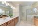 Bright bathroom features double sinks, a glass shower, and tile flooring at 324 Whispering Palms Ln, Bradenton, FL 34212
