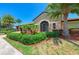 Attractive clubhouse entrance featuring stone accents, lush landscaping, and an inviting front door at 324 Whispering Palms Ln, Bradenton, FL 34212