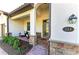 Charming front porch with stone accents, a cozy seating area, and a stylish entrance at 324 Whispering Palms Ln, Bradenton, FL 34212