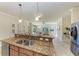 Granite kitchen island with stainless sink and faucet, plus stainless refrigerator in background at 324 Whispering Palms Ln, Bradenton, FL 34212