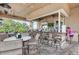 Outdoor bar with barstool seating, an outdoor TV, and surrounding tables with chairs at 324 Whispering Palms Ln, Bradenton, FL 34212
