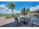 Inviting outdoor patio featuring comfortable seating, tables, and lush landscaping with palm trees overlooking the golf course at 324 Whispering Palms Ln, Bradenton, FL 34212