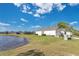 Backyard view with a pond, lawn, and the back of the house featuring neutral-toned siding at 3831 Creekside Park Dr, Parrish, FL 34219