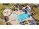 Aerial view of a large community pool, playground, splash pad, and outdoor lounge chairs and palm trees at 3831 Creekside Park Dr, Parrish, FL 34219