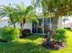 Beautiful backyard featuring lush green grass, tropical palm trees, and a sliding glass door leading indoors at 4155 Cascade Falls Dr, Sarasota, FL 34243