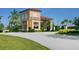 An impressive guard house provides security and style to this community entrance, framed by palms and lush plantings at 4155 Cascade Falls Dr, Sarasota, FL 34243