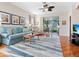Cozy living room with wood floors, stylish blue sofa, modern ceiling fan, and a serene view of the screened-in patio at 4155 Cascade Falls Dr, Sarasota, FL 34243