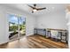 Bright bedroom featuring wood floors, ceiling fan, and sliding glass doors to the outdoor space at 4196 Eastlake Ct, Port Charlotte, FL 33948