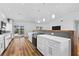 Open kitchen with white cabinets, quartz counters, wood floors and stainless steel appliances at 4196 Eastlake Ct, Port Charlotte, FL 33948