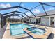 Relax in this screened-in pool with an attached jacuzzi and outdoor furniture at 4196 Eastlake Ct, Port Charlotte, FL 33948