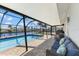 Relax in this screened-in pool with comfortable outdoor seating overlooking a tranquil canal at 4196 Eastlake Ct, Port Charlotte, FL 33948