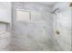 Modern shower with marble tiling, built in shelf, and gold fixtures at 4196 Eastlake Ct, Port Charlotte, FL 33948