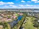 Aerial view of the condominium community with nearby park and lakes, surrounded by lush greenery at 5552 Bentgrass Dr # 7-116, Sarasota, FL 34235