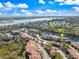 Scenic aerial view of the community featuring beautiful lake views, lush green trees and community landscape under a bright sunny sky at 5552 Bentgrass Dr # 7-116, Sarasota, FL 34235